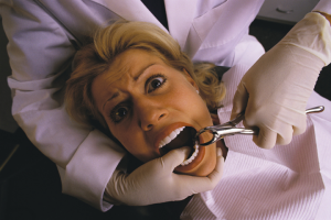 矯正医に歯を抜かれる女性の画像